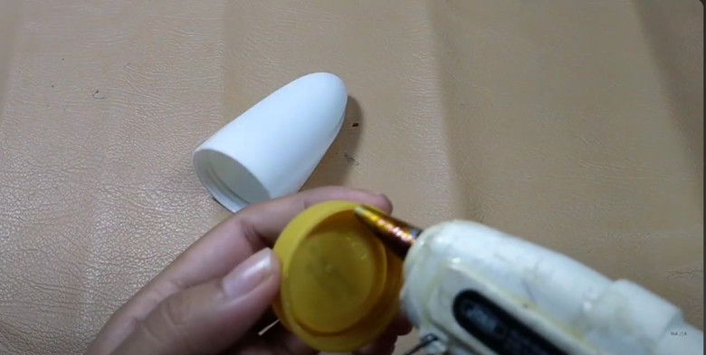 1. Siapkan tempat deodoran bekas yang sudah dibersihkan dalamnya dan tutup botol, lalu lem tutup botol melingkar.
