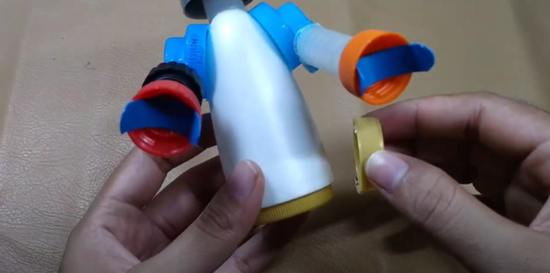 16 Siapkan Tutup botol lagi untuk dijadikan pondasi kaki alien. Cara penyatuannya dengan di Lem