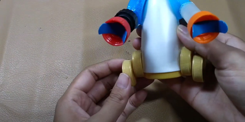 17. Tempelkan tutup botol pada masing- masing sisi