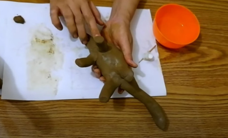 7. Setelah itu giliran tempelkan cetakan kaki yang kecil/ lebih pendek pada bagian belakang, pijit kaki agar nempel pada tubuh Brontosaurus. Jangan lupa olesin air agar tesktur lebih halus
